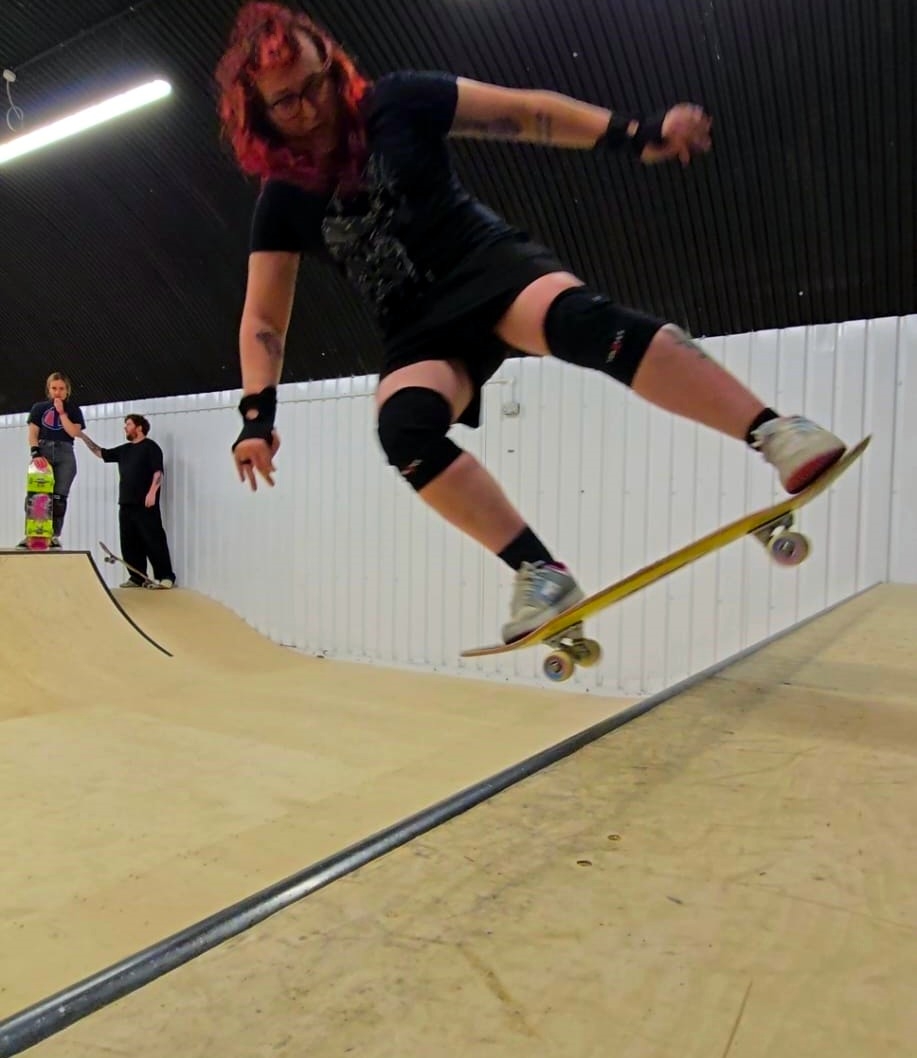 Aya on a skateboard with 1 foot of air over the coping